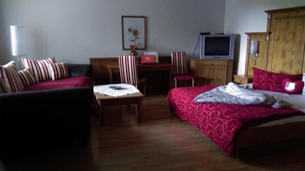 1 dormitorio con cama, sofá y mesa en Weinhaus Eva-Maria Wagner, en Eisenstadt
