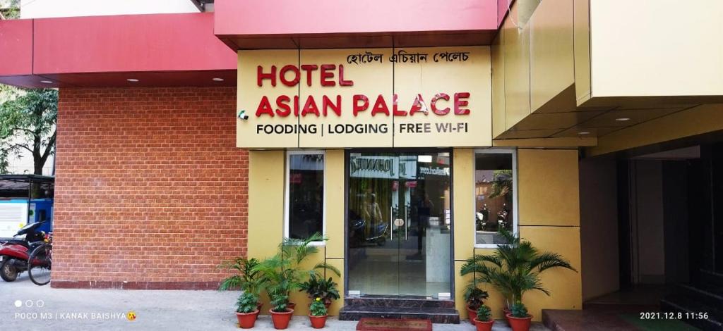 a hotel asian palace with potted plants in front of it at Hotel Asian Palace in Guwahati