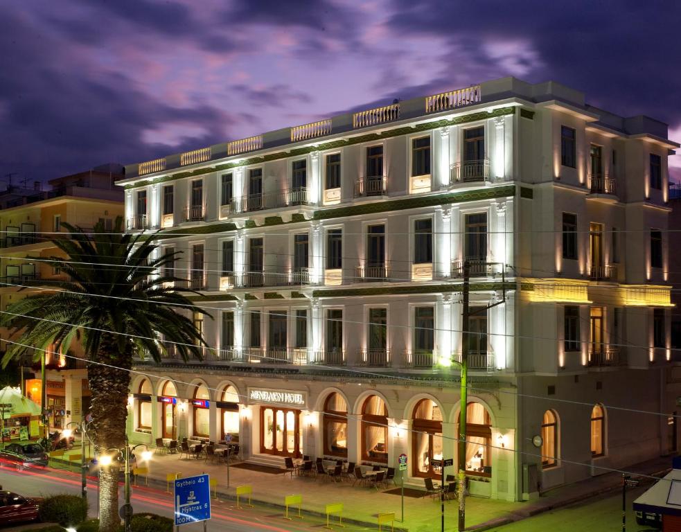 ein großes weißes Gebäude in einer Stadtstraße bei Nacht in der Unterkunft Menelaion Hotel in Sparta