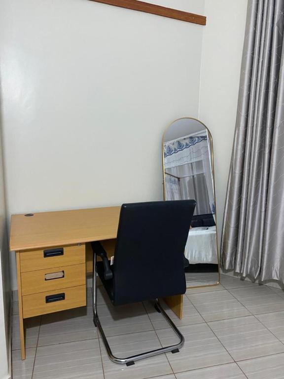 a desk with a chair and a mirror in a room at Rippon Nest in Jinja