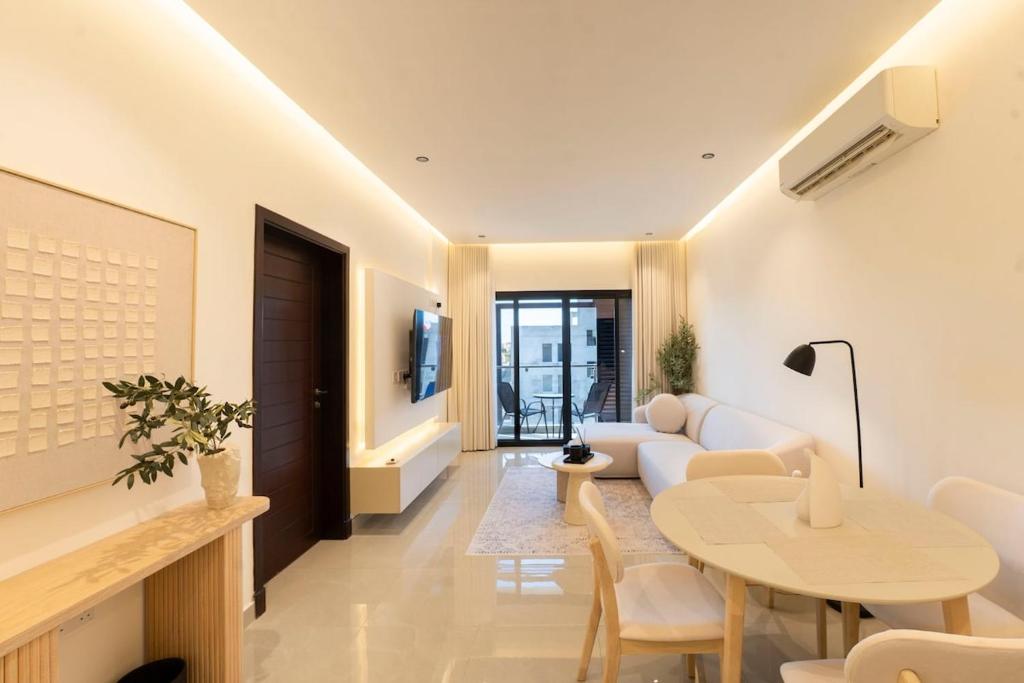 a living room with a couch and a table at Beige Apartment by Bait Zain - Bousher in Muscat