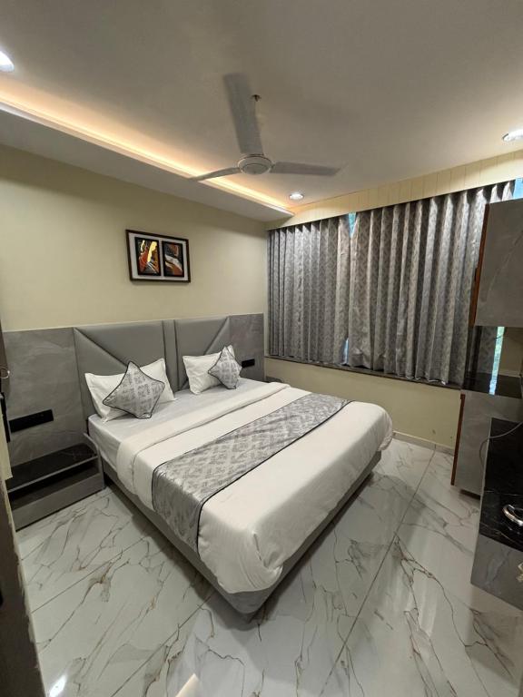 a bedroom with a large bed and a large window at Hotel Planet Town in Ahmedabad