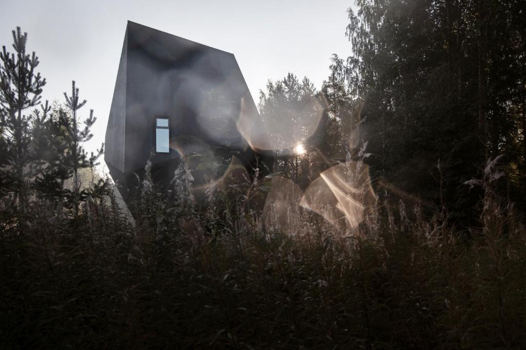 a house in the middle of a field of grass at Meteorite House in Kontiolahti