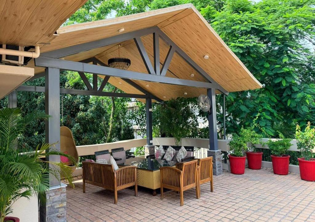 a wooden pavilion with chairs and a table at The Mars Sphere in Dehradun