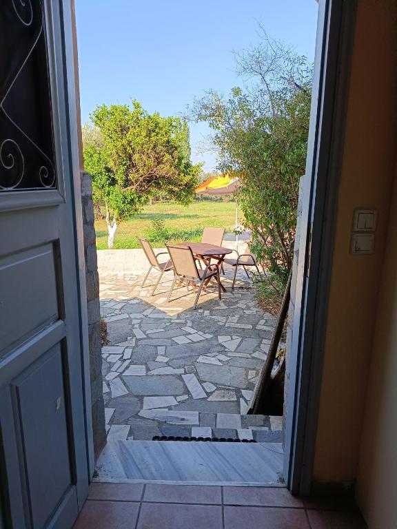 an open door to a patio with a table and chairs at Seaside olive grove in Pyrgi Thermis