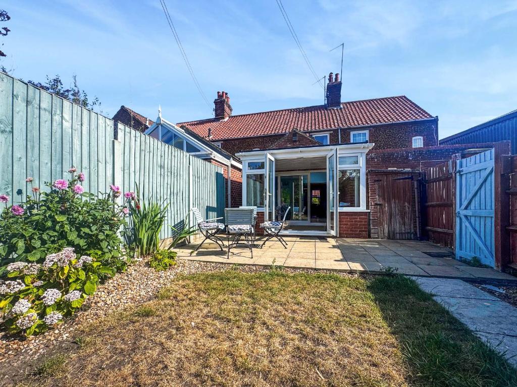 a home with a fence and a patio at Penny Cottage in Heacham