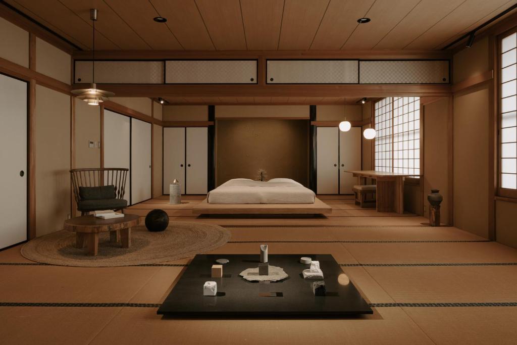 a room with a bed and a table in it at o ku in Awaji
