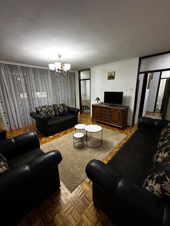 a living room with couches and a table and a tv at TAMARIS Apartment in Subotica