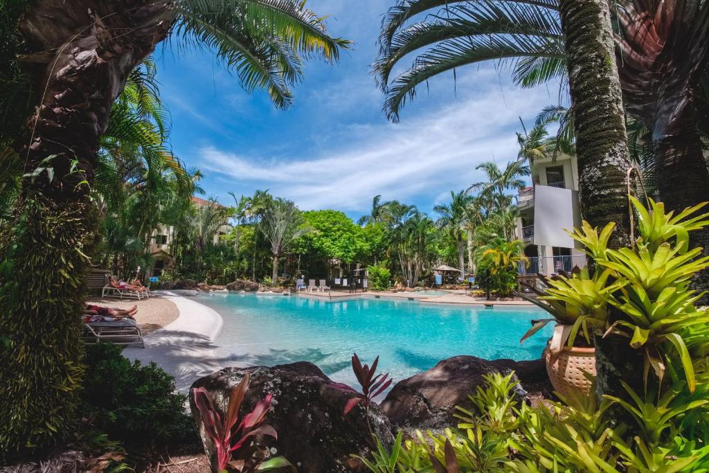 a pool at a resort with palm trees at Sanctuary Lake Apartments in Gold Coast