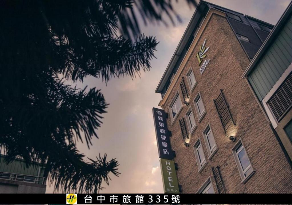 a tall brick building with a sign in front of it at Kiwi Express Hotel-Taichung Station II in Taichung