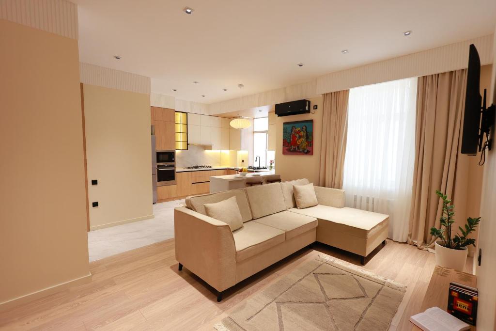 a living room with a couch and a kitchen at PANA Apartments in Nukus