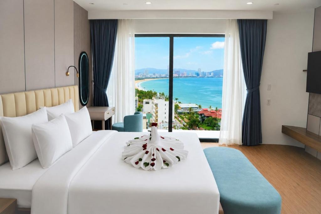 a hotel room with a bed and a view of the ocean at The Golden Crest Hotel Quy Nhon in Quy Nhon
