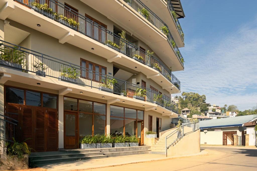 an apartment building with potted plants on the balconies at Oak Ray Sky Terrace in Kandy