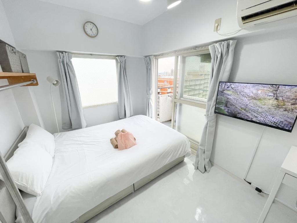 a small bedroom with a teddy bear on a bed at Kameari 911 - 9F Newly Renovated Corner Room High Floor Near Station Mall Disney Access in Tokyo