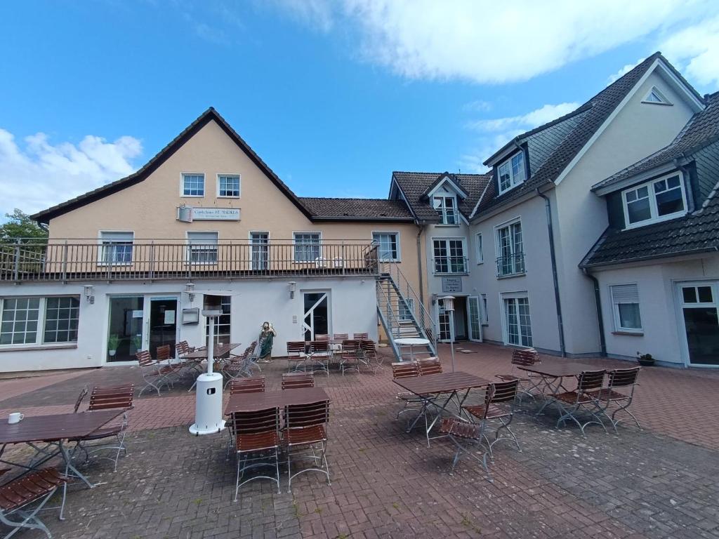 a building with tables and chairs in front of it at Gästehaus St Markus in Höxter