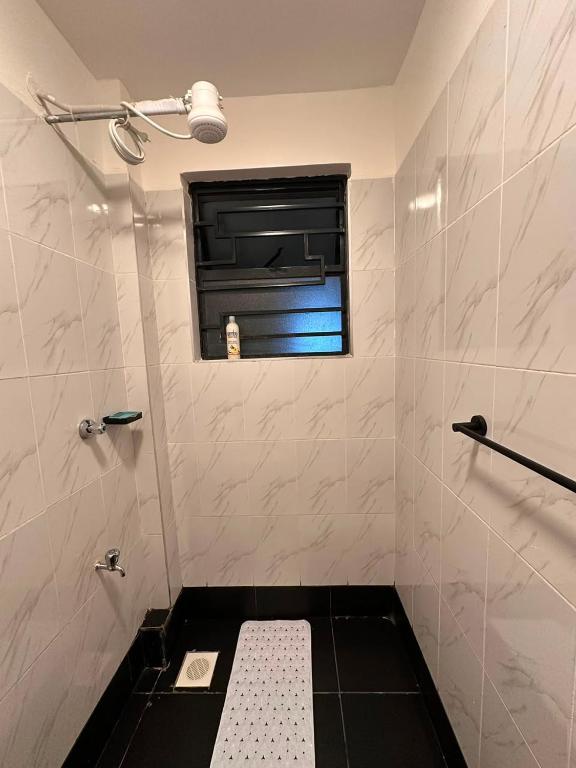 a bathroom with a window and a toilet in it at Homes by Sil Bn in Muchatha