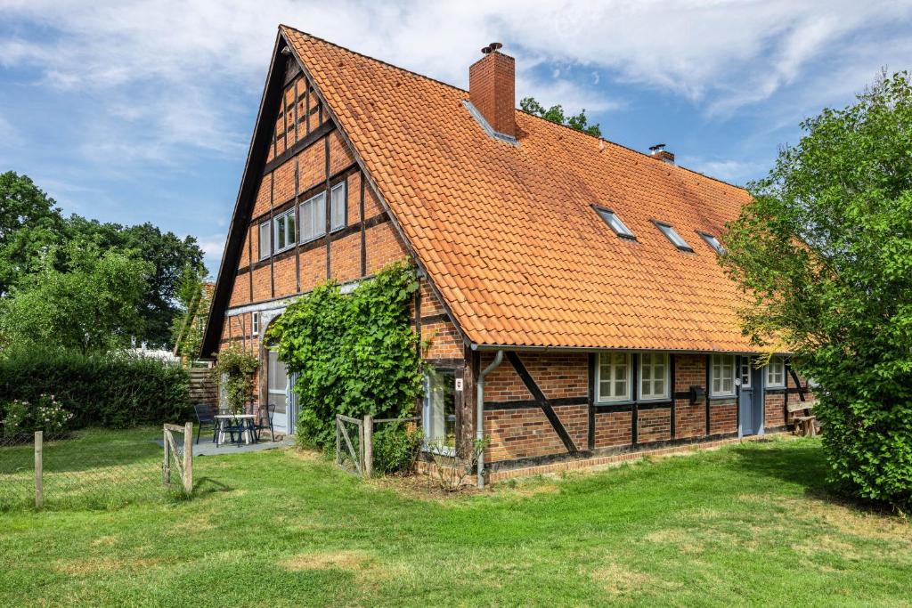 a large wooden house with an orange roof at Deelenwohnung in Trebel