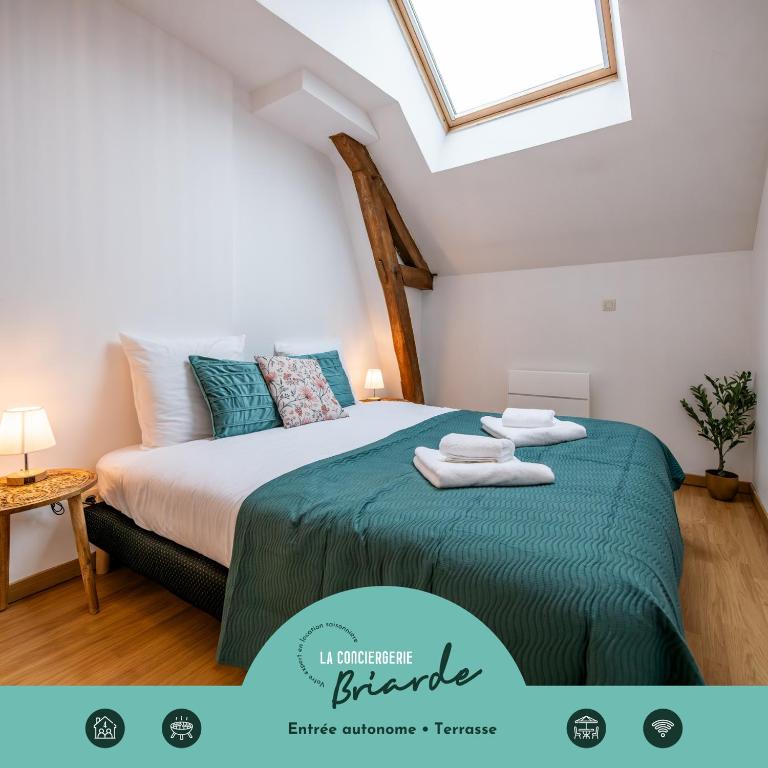 a bedroom with a bed with towels on it at Le Triplex - cosy avec petit jardin in Longueville