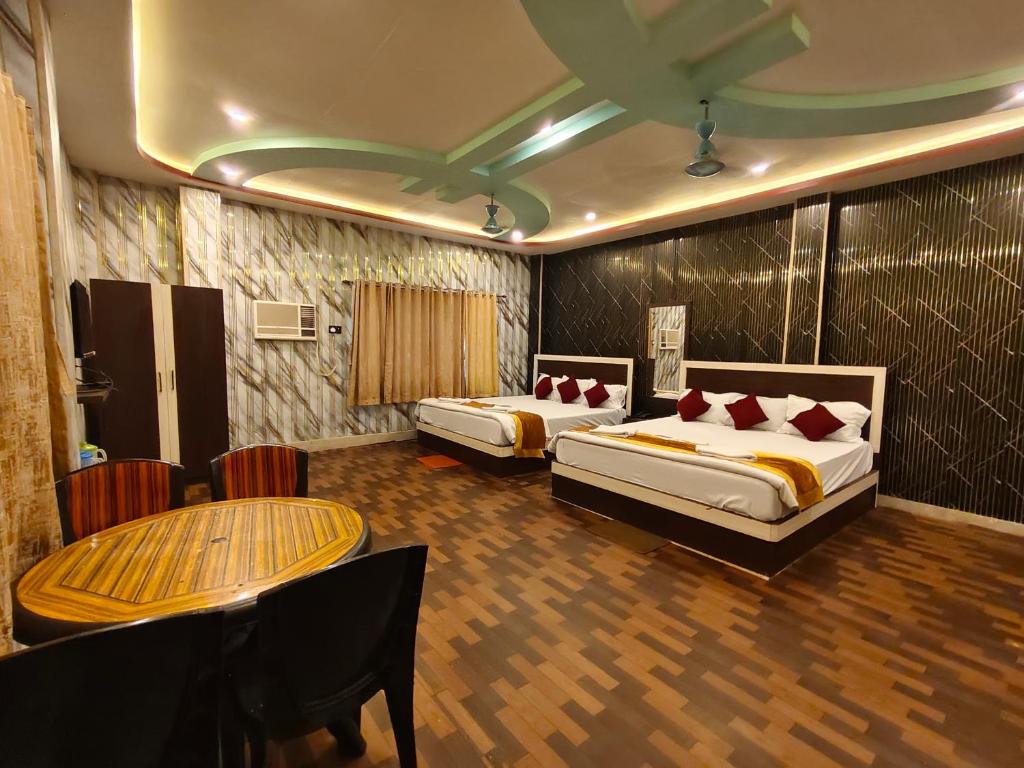 a hotel room with two beds and a table at ICONIC Hotel Digha in Digha
