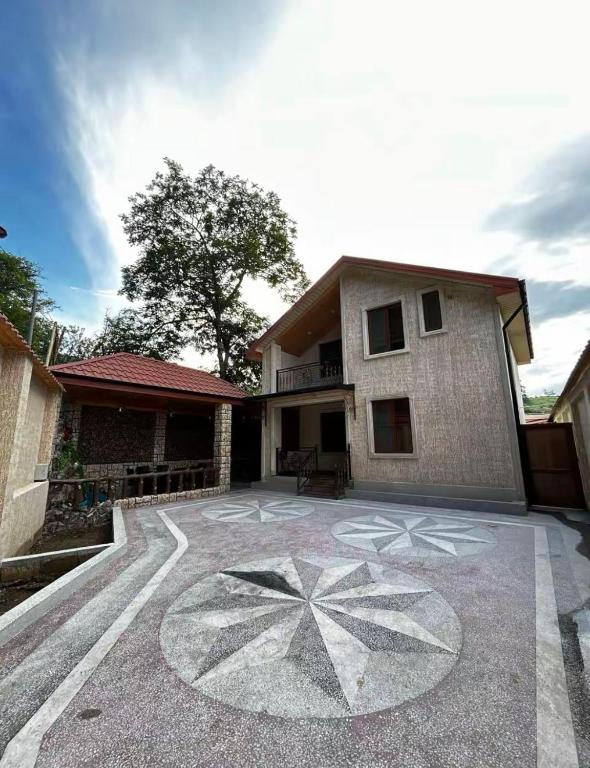 a house with a drawing on the ground in front of it at Yusubovs in Hacıkǝnd