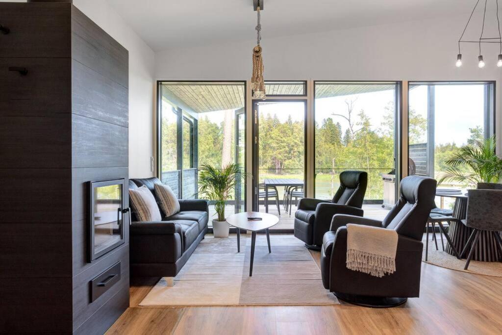 a living room with a couch and chairs and a tv at Villa Syreeni - Seafront/Jacuzzi in Kilpilahti
