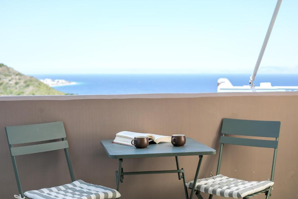 a table with two chairs and a table with a book at Sea View Apartment in Rhodes Town