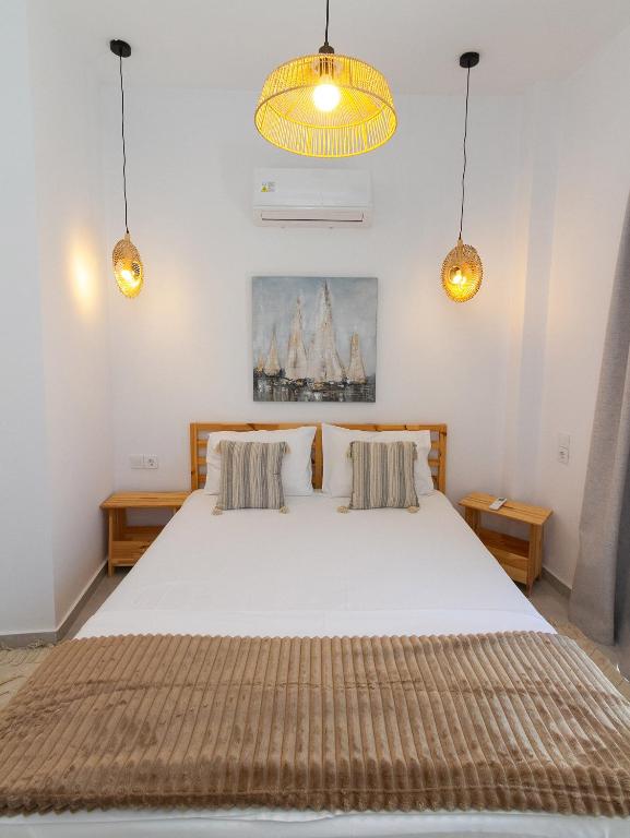 a bedroom with a large white bed with two pillows at The Minimal Apartments 3Floors in Loutra Edipsou