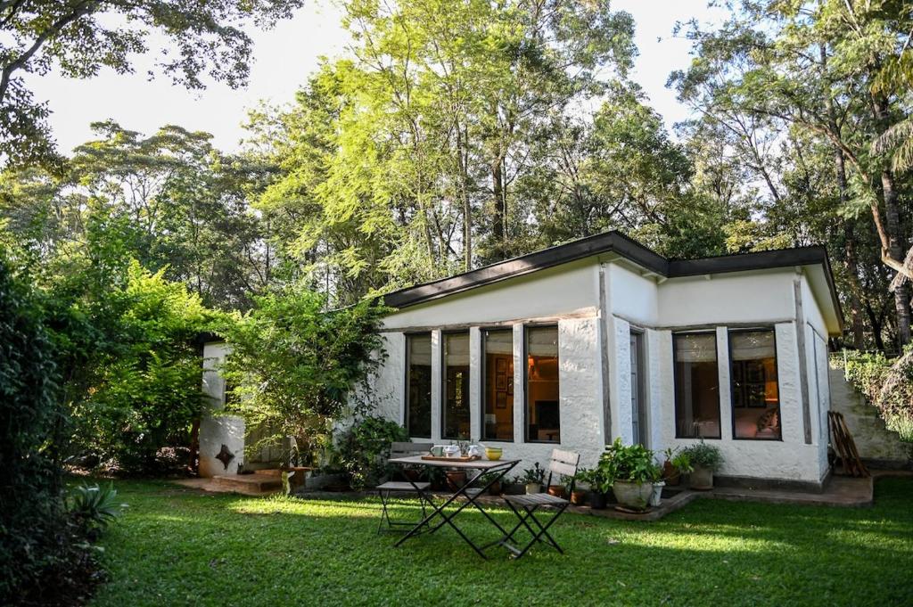 a small white house with a table in the yard at The Dogbox, Karen in Nairobi