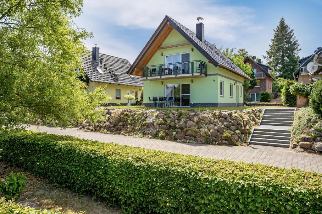 a yellow house with a stone retaining wall at Haus U13 in Röbel