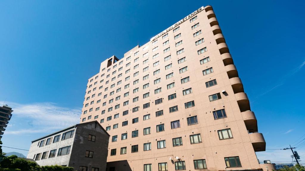 ein hohes Gebäude vor blauem Himmel in der Unterkunft Hotel Sun Valley Annex in Beppu