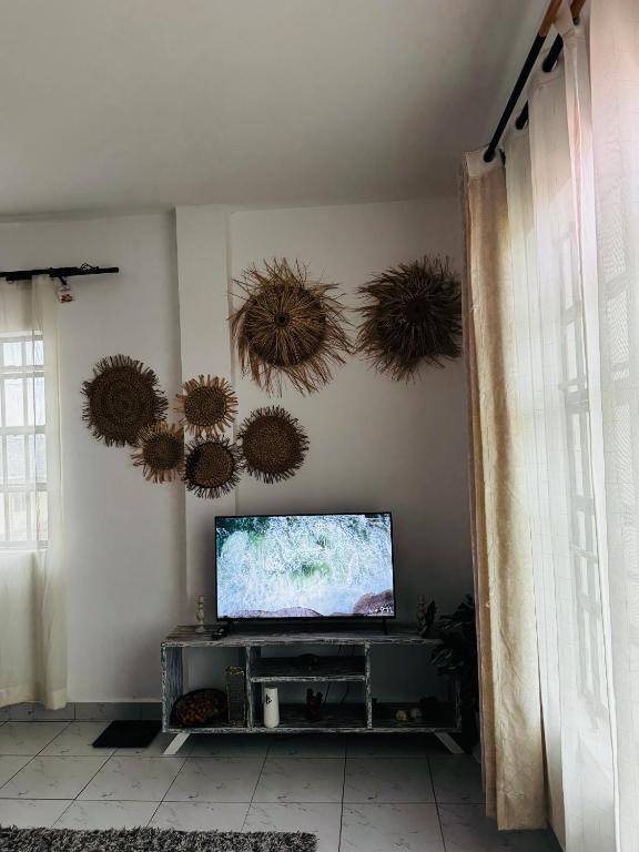 a living room with a flat screen tv on a wall at Atieno home in Kwale