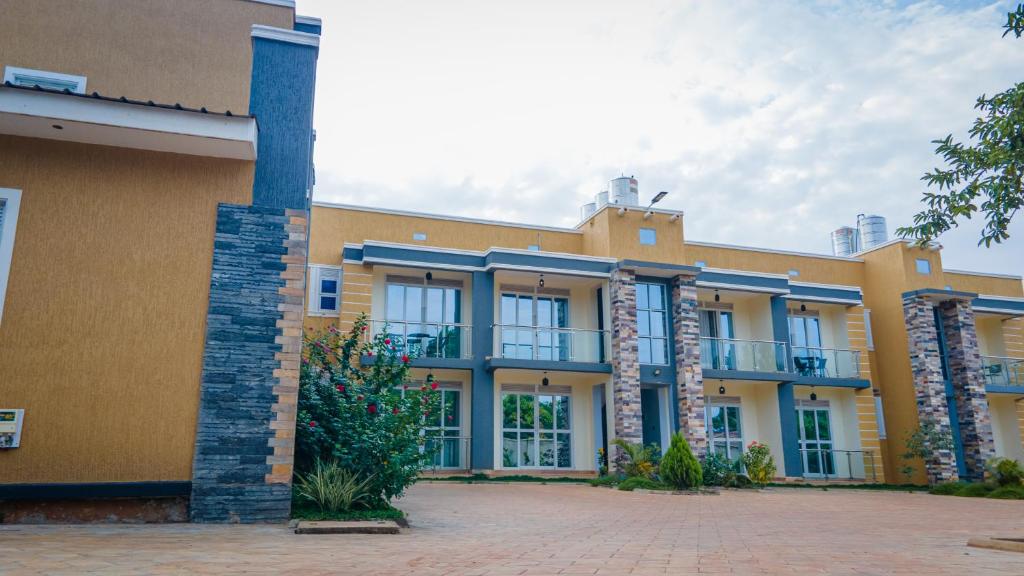 a large yellow building with balconies on it at E-Residences in Gulu
