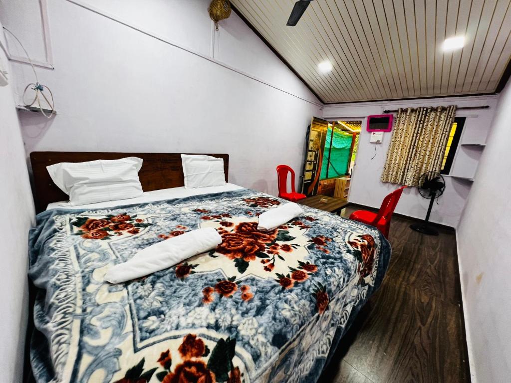 a bedroom with a bed and two red chairs at Lake breeze homestay in Shendi