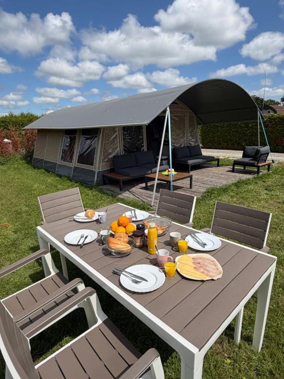 a table with food on it with a tent at Glamping in Style in Dronrijp