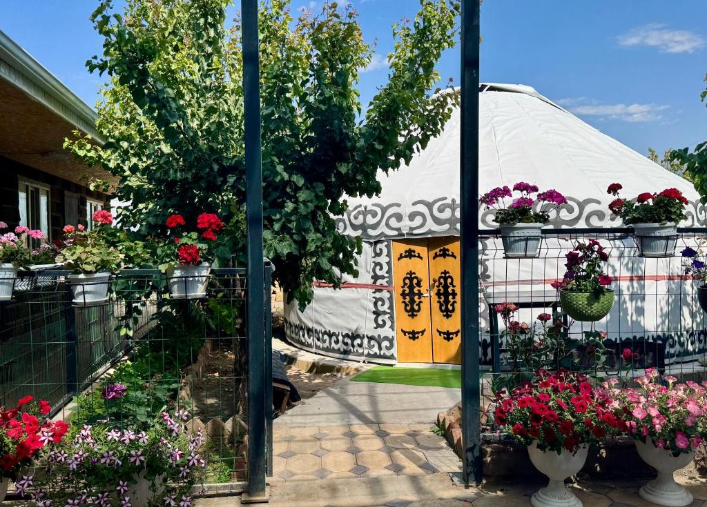 a reflection of a garden with flowers in a mirror at Sabi Guest House in Bokonbayevo