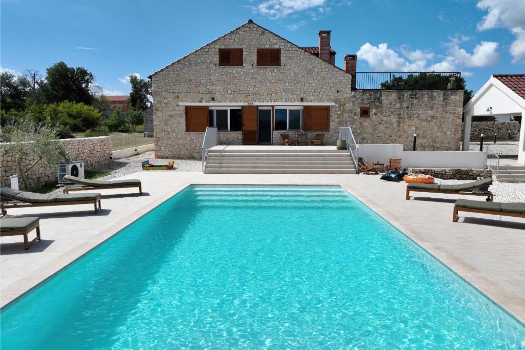 a swimming pool in front of a house at Villa Demare with Heated Pool, Free EVC Station in Lovinac