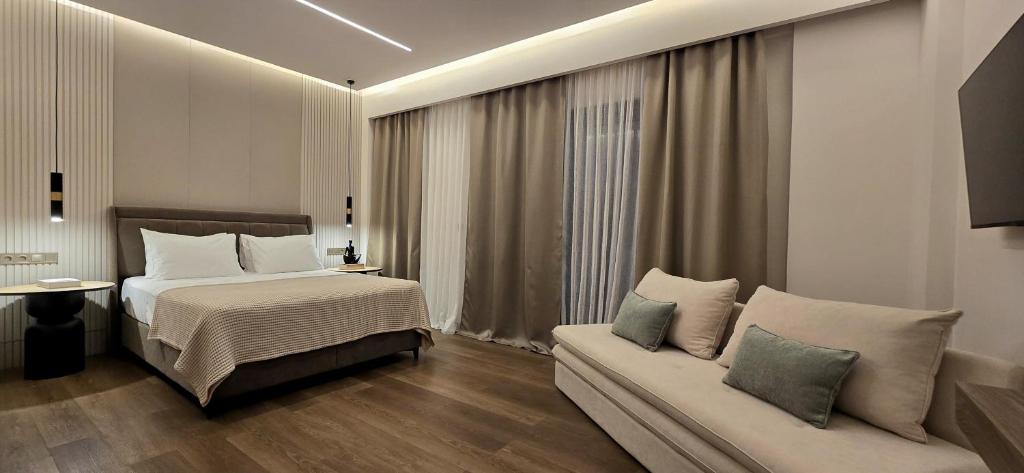 a hotel room with a bed and a couch at LUMINA Luxury Suites in Missolonghi