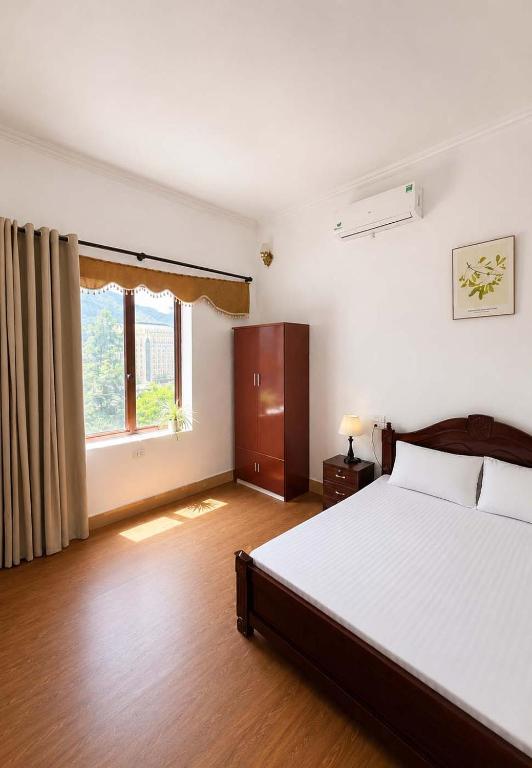 a bedroom with a large bed and a window at Nhà nghỉ Hoa Ngàn Tam Đảo in Tam Ðảo