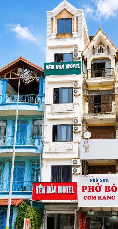 a tall white building with signs on it at YÊN HÒA MOTEL in Hanoi