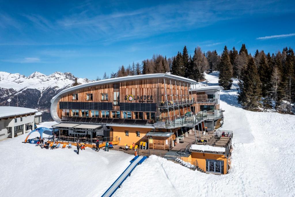 a building on top of a snow covered mountain at Hotel Rifugio Solander in Commezzadura