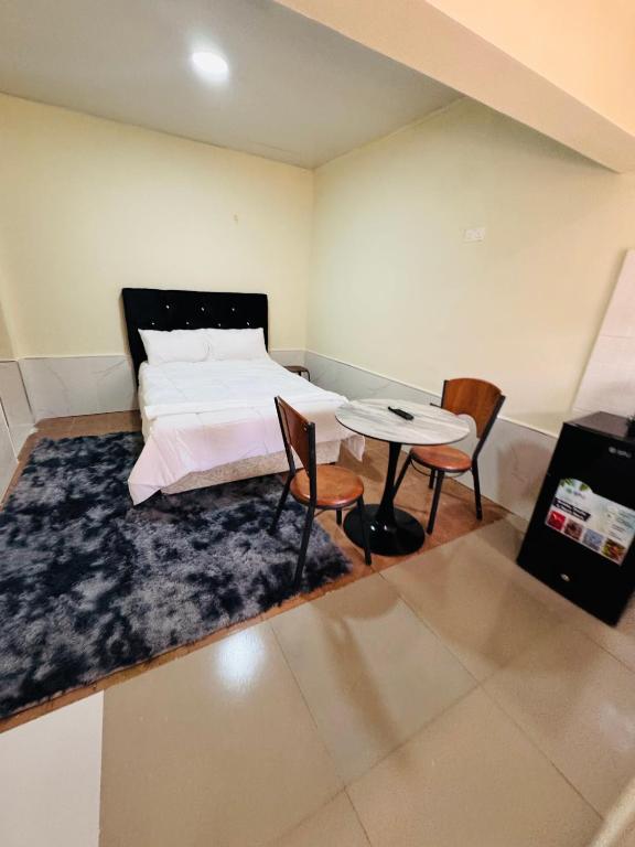 a bedroom with a bed and a table and chairs at ELISAM Cabin 2 in Kitwe