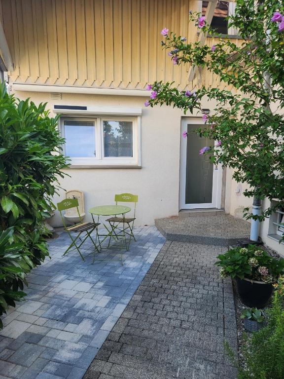 a patio with chairs and a table in front of a building at L'Escapade de Zillis in Zillisheim
