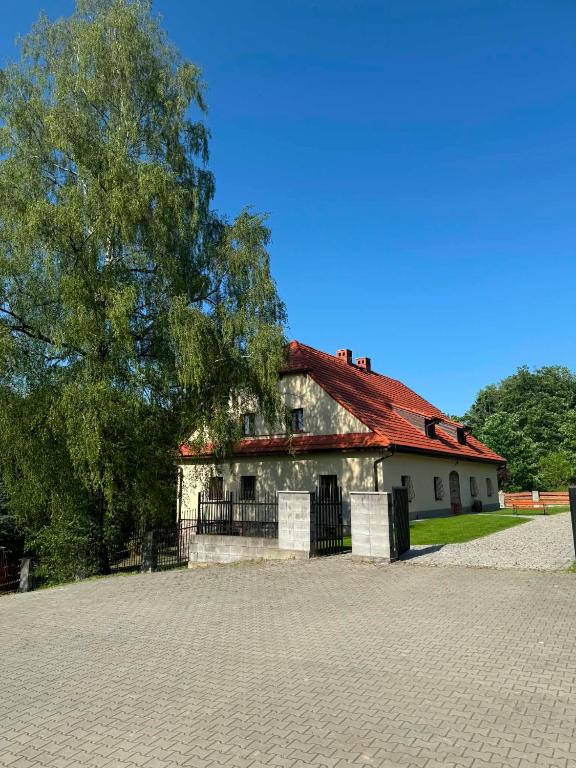an old house with a red roof and a tree at Kousek ráje in Třinec