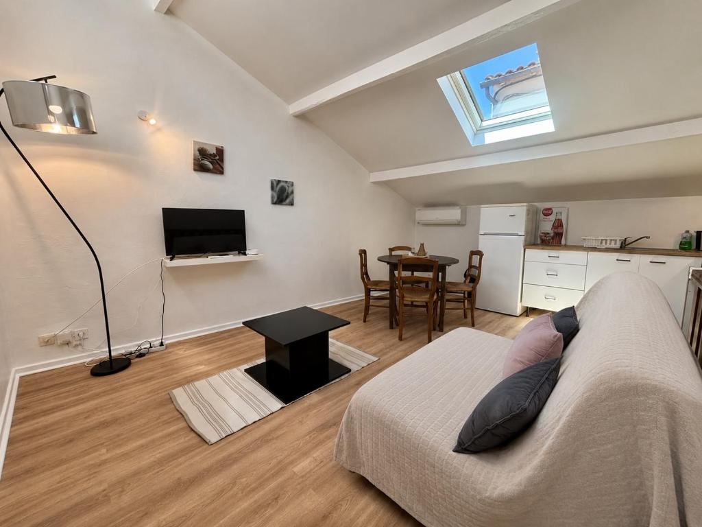 a living room with a bed and a table at Charmant Duplex climatisé, Centre de Cahors in Cahors