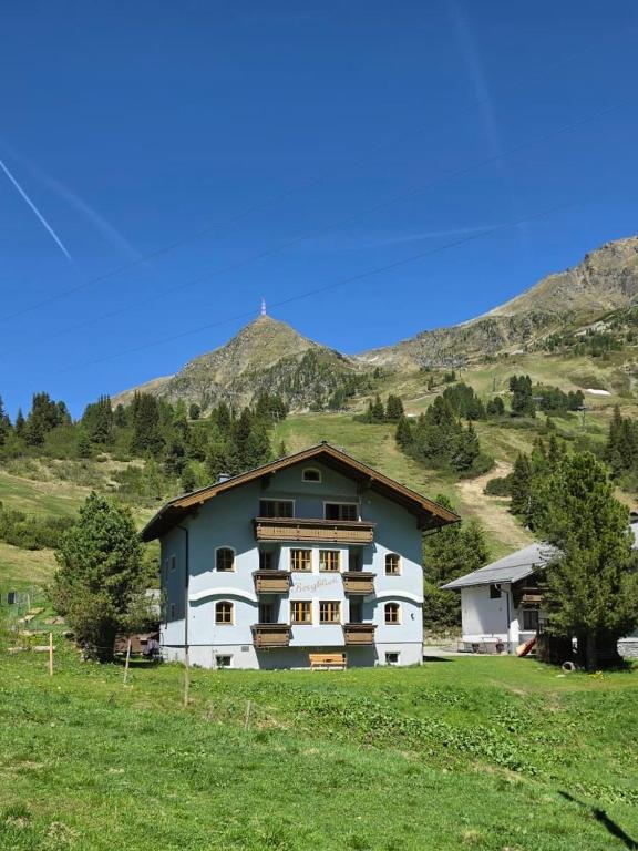 a house in a field with mountains in the background at Haus Bergblick in Obertauern
