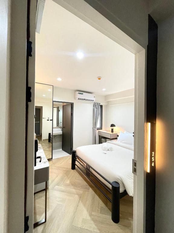 a bedroom with a bed and a desk and a mirror at RESET at DMK Hotel in Don Muang Airport