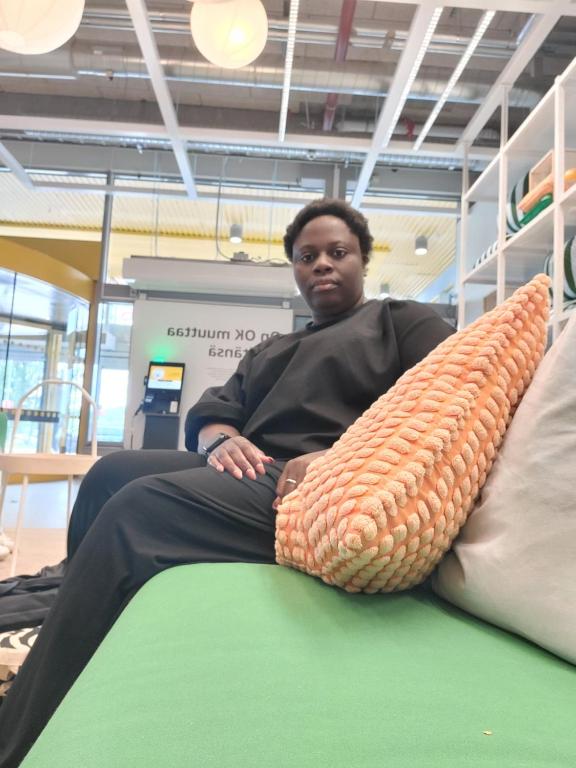 a man sitting on a pillow with an ear of corn at Apartment in Espoo
