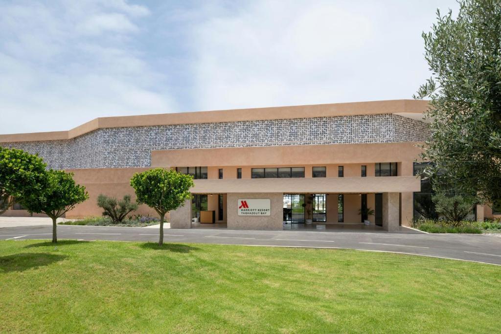 a large building with a lawn in front of it at Taghazout Bay Marriott Resort in Taghazout