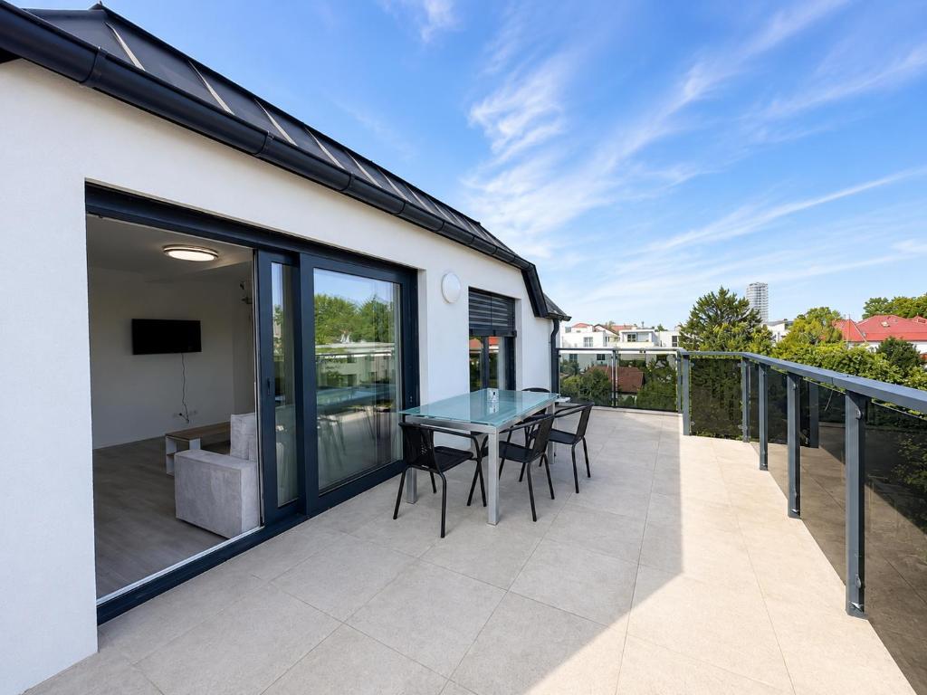 a patio with a table and chairs on a balcony at TO-HAD, Modern Apartments next to U-bahn with free Wifi in Vienna