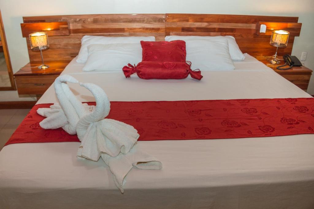 1 dormitorio con 1 cama con manta roja y blanca en Hotel Golden Star en Iquitos